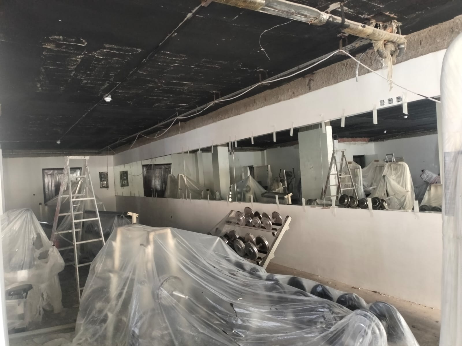 Large wall-mounted gym mirror installation