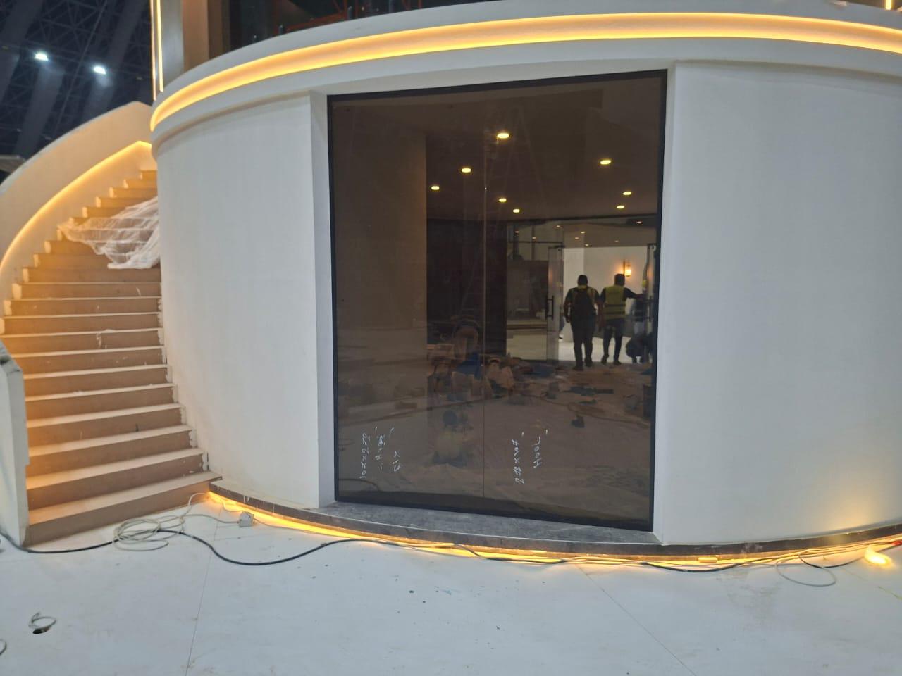 Curved tinted glass facade with grand staircase